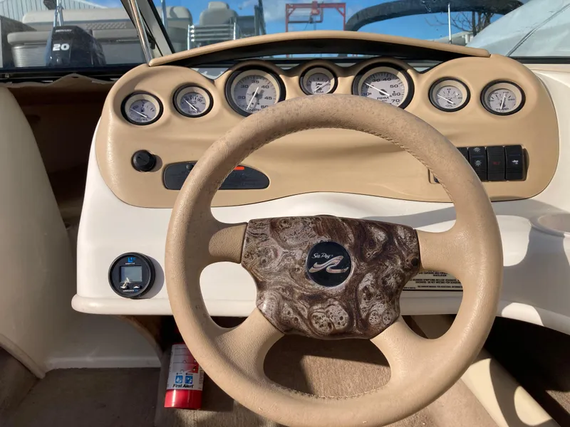 Slide: The Image of 2001 Sea Ray 180 Bow Rider dashboard with steering wheel and gauges. - 10