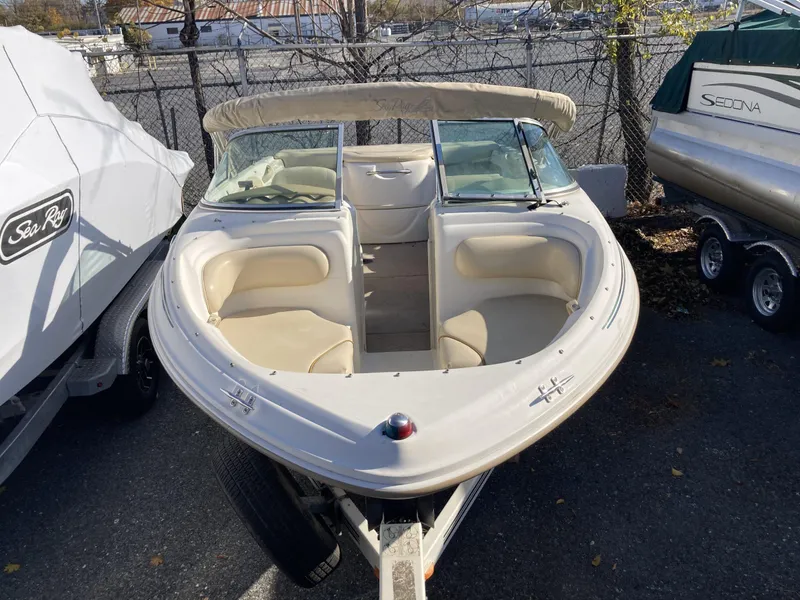 Slide: The Image of 2001 Sea Ray 180 Bow Rider boat with beige interior, parked on a trailer. - 2