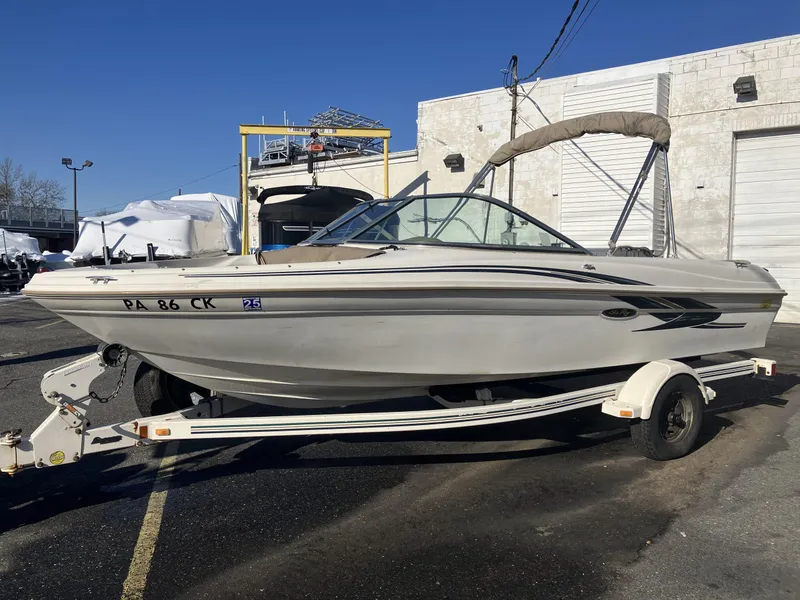 Slide: The Image of 2001 Sea Ray 180 Bow Rider boat on trailer, parked outdoors. - 3