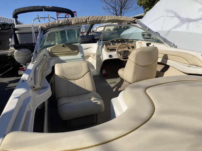 Slide: The Image of 2001 Sea Ray 180 Bow Rider interior with beige seating and dashboard. - 6