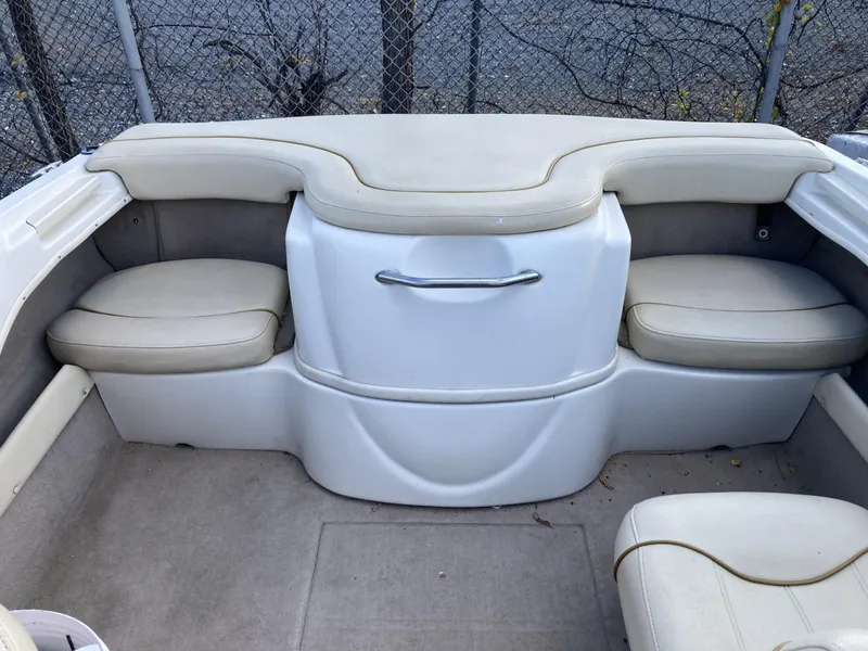 Slide: The Image of 2001 Sea Ray 180 Bow Rider interior with beige seating and storage compartment. - 8