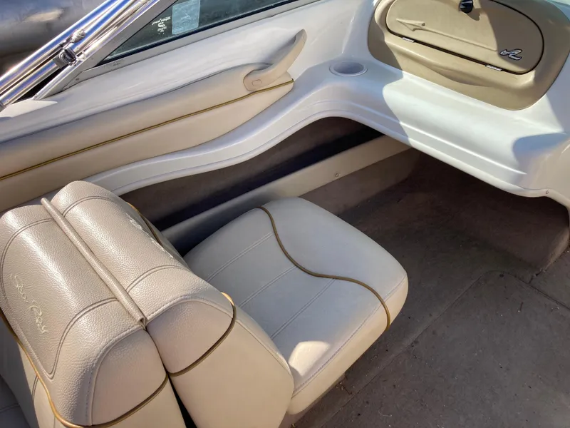 Slide: The Image of 2001 Sea Ray 180 Bow Rider interior with beige seating and storage compartment. - 9