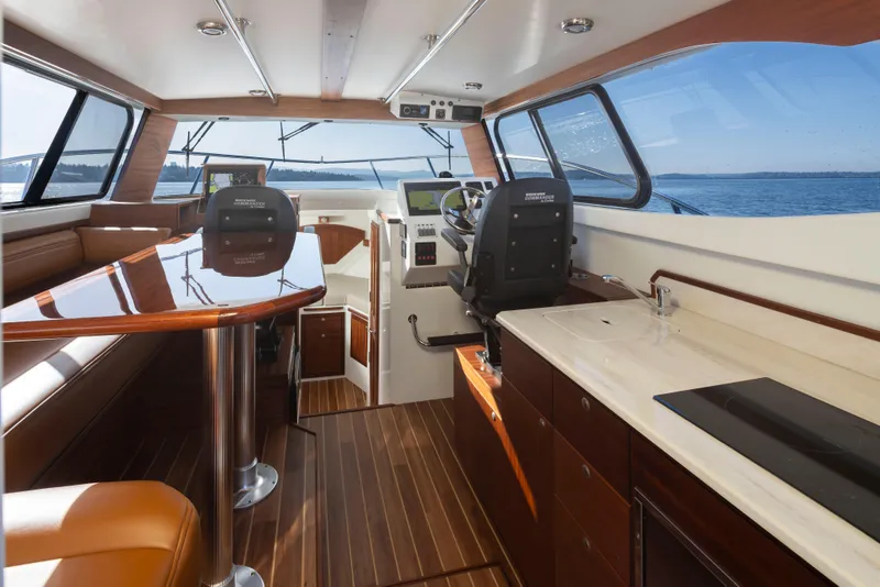 Slide: The Image of Interior of 2025 Ocean Sport Roamer boat with modern helm and luxurious seating. - 13