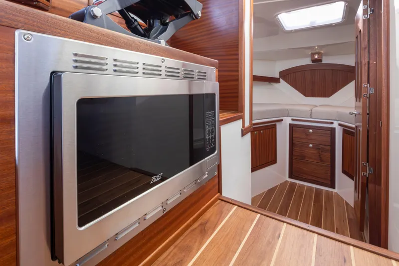 Slide: The Image of 2025 Ocean Sport Roamer interior with microwave, wooden cabinetry, and modern design. - 15