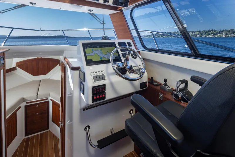 Slide: The Image of 2025 Ocean Sport Roamer boat interior with navigation system and steering wheel. - 16