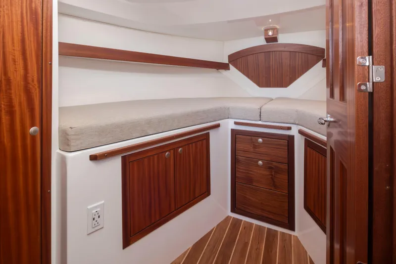 Slide: The Image of 2025 Ocean Sport Roamer cabin with wooden cabinetry and cushioned seating. - 18