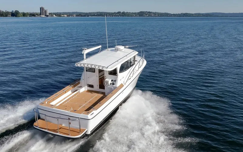 Slide: The Image of 2025 Ocean Sport Roamer boat cruising on open water, showcasing sleek design and performance. - 2