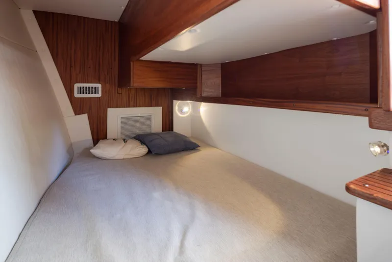 Slide: The Image of 2025 Ocean Sport Roamer cabin interior with cozy bed and wooden accents. - 23