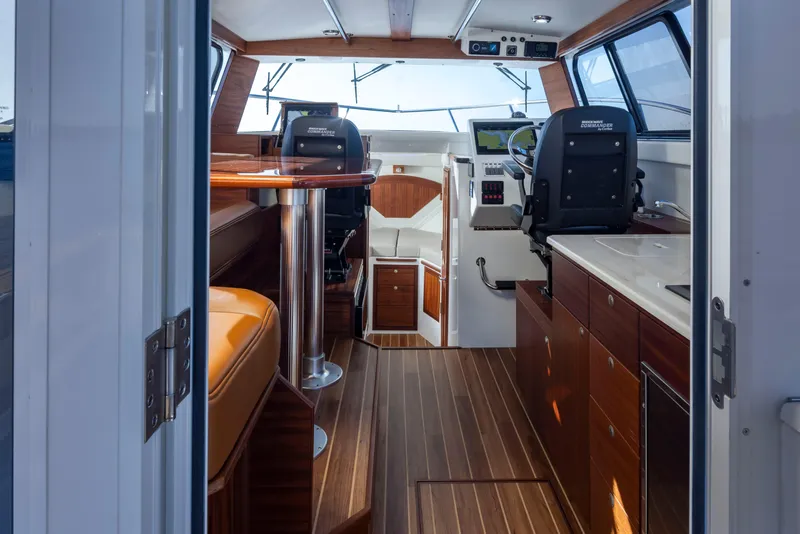 Slide: The Image of Interior of 2025 Ocean Sport Roamer boat with modern seating and navigation equipment. - 24