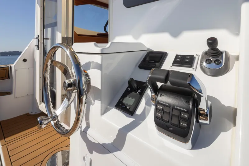 Slide: The Image of Control panel of 2025 Ocean Sport Roamer boat with steering wheel and throttle. - 27