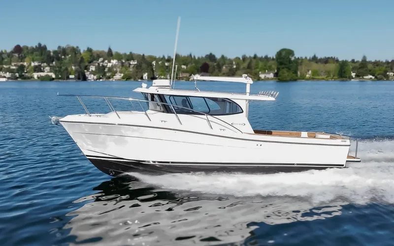 Slide: The Image of 2025 Ocean Sport Roamer cruising on a serene lake under a clear blue sky. - 5