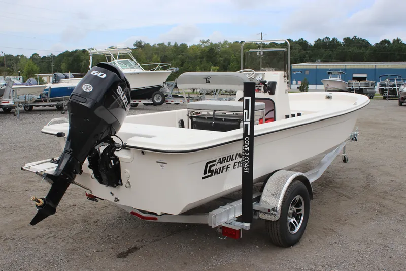 Slide: The Image of 2025 Carolina Skiff E18 JVX CC boat on trailer, featuring a 60 HP outboard motor. - 2