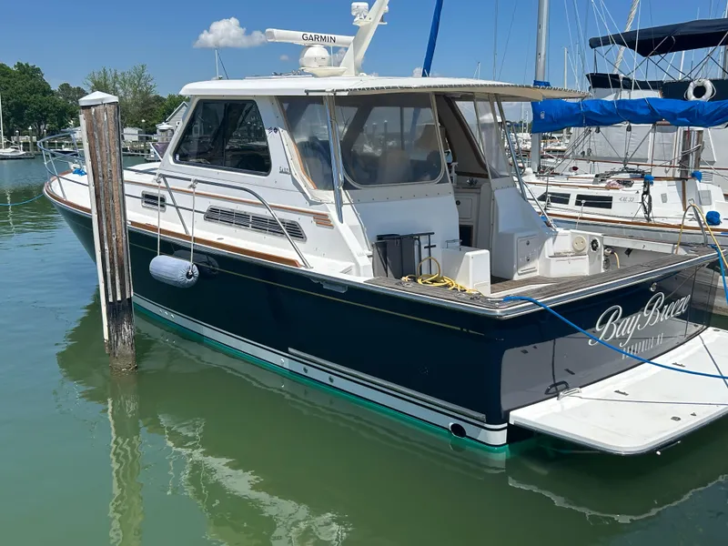 Slide: The Image of 2005 Sabre 38 boat docked in marina, featuring sleek design and white cabin. - 0