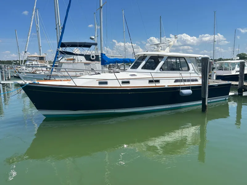 Slide: The Image of 2005 Sabre 38 yacht docked in a marina under a clear blue sky. - 1