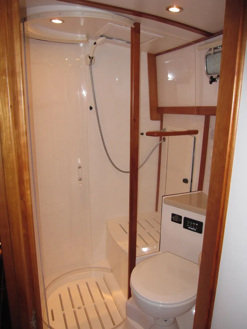 Slide: The Image of 2005 Sabre 38 yacht bathroom with shower, toilet, and wooden accents. - 14