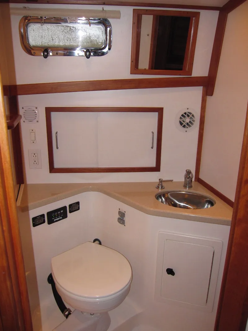 Slide: The Image of 2005 Sabre 38 yacht bathroom with sink, toilet, and storage cabinets. - 15