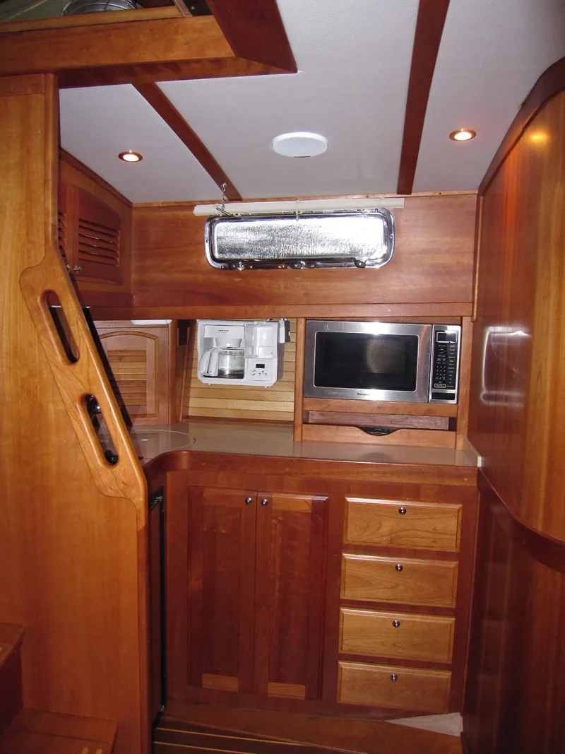 Slide: The Image of 2005 Sabre 38 yacht interior with wooden cabinetry, microwave, and modern amenities. - 16