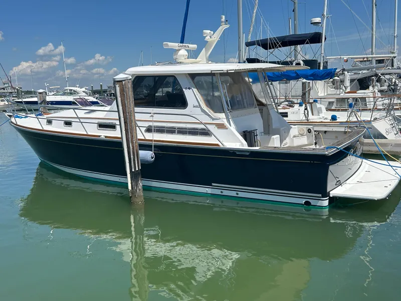 Slide: The Image of 2005 Sabre 38 boat docked in a marina under clear blue skies. - 2