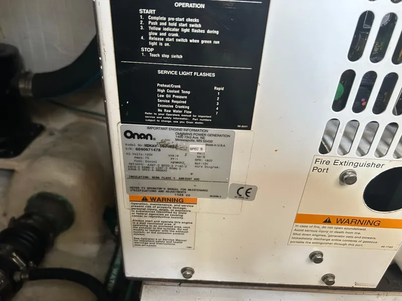 Slide: The Image of Onan generator control panel with operation instructions and warning labels on a 2005 Sabre 38. - 28