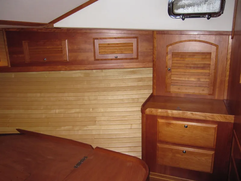 Slide: The Image of Wooden interior of a 2005 Sabre 38 boat, featuring cabinets and drawers. - 9