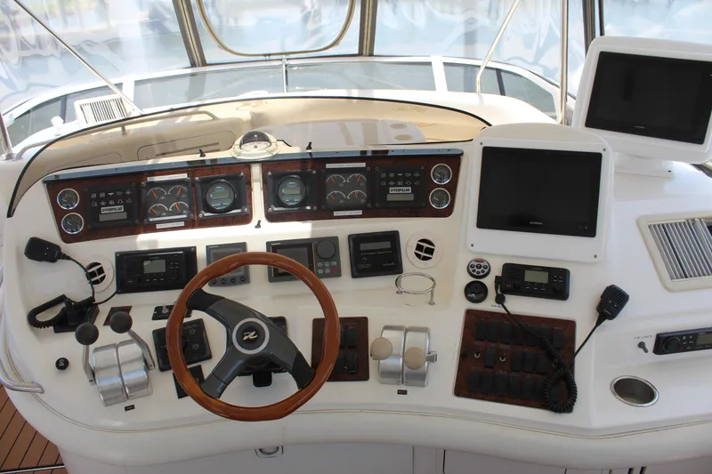 Slide: The Image of Control panel of a 2000 Sea Ray 480 Sedan Bridge yacht with steering wheel and navigation instruments. - 13