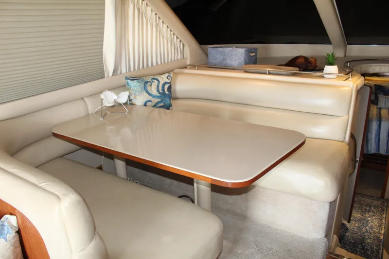 Slide: The Image of Interior of 2000 Sea Ray 480 Sedan Bridge with beige seating and dining table. - 28