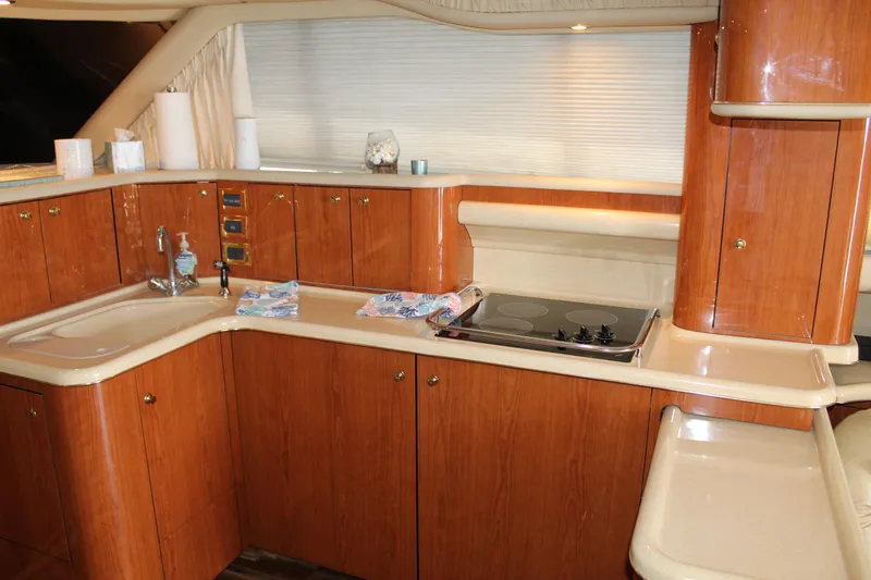 Slide: The Image of Luxurious kitchen interior of 2000 Sea Ray 480 Sedan Bridge yacht with wooden cabinetry. - 29