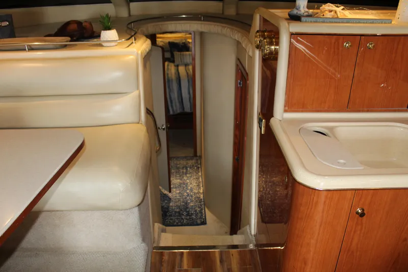 Slide: The Image of Interior of 2000 Sea Ray 480 Sedan Bridge yacht, featuring cozy seating and wooden cabinetry. - 30
