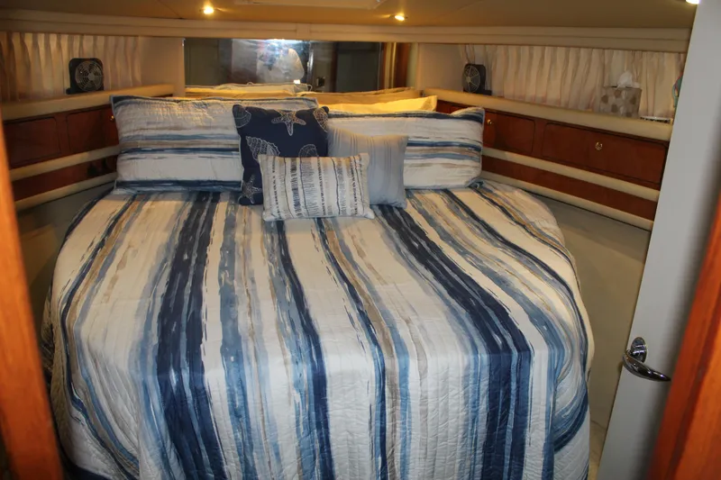 Slide: The Image of Luxurious bedroom interior of 2000 Sea Ray 480 Sedan Bridge yacht with striped bedding. - 32