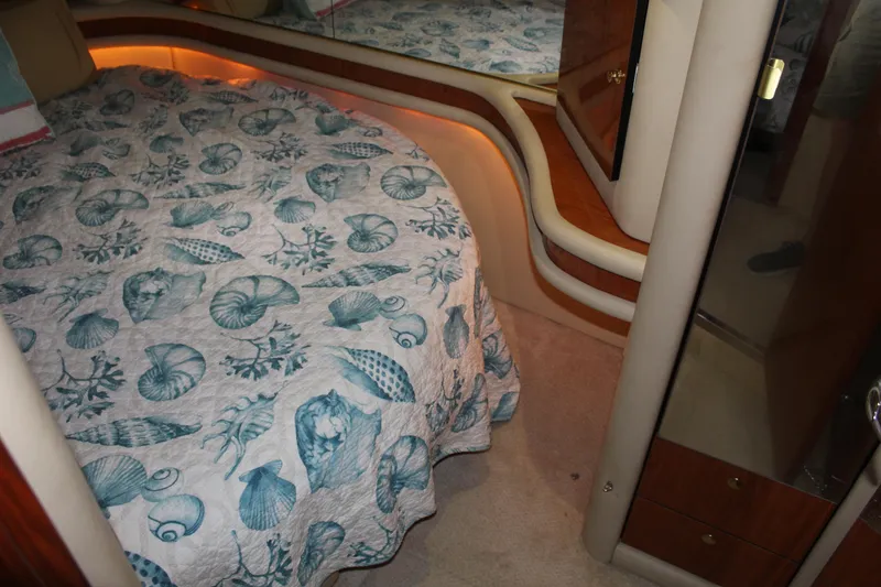 Slide: The Image of Interior cabin of 2000 Sea Ray 480 Sedan Bridge with seashell-patterned bedding. - 37
