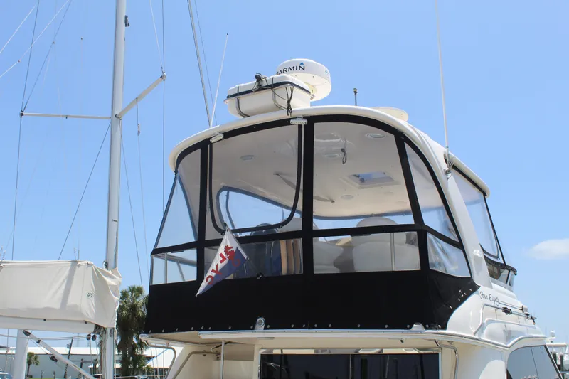 Slide: The Image of 2000 Sea Ray 480 Sedan Bridge yacht with enclosed flybridge, docked under clear blue sky. - 4