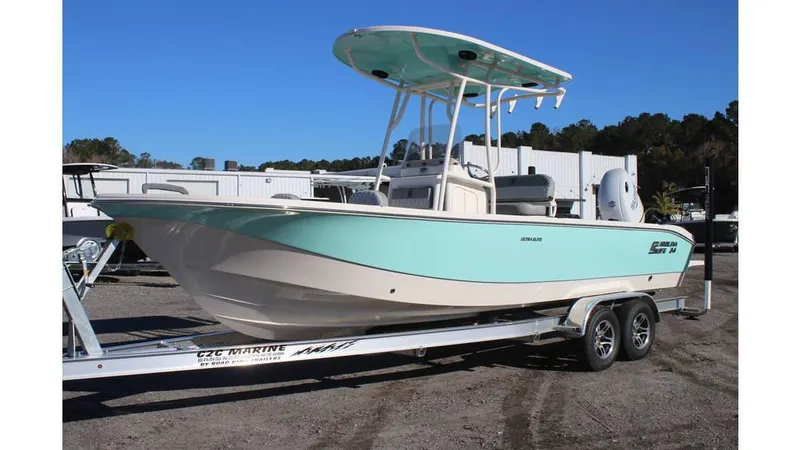 The Image of 2025 Carolina Skiff 24 Ultra Elite boat on trailer, light blue hull, parked outdoors. - 0