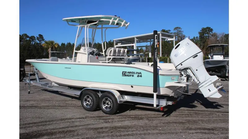 Slide: The Image of 2025 Carolina Skiff 24 Ultra Elite boat on trailer, light blue hull, outboard motor. - 3