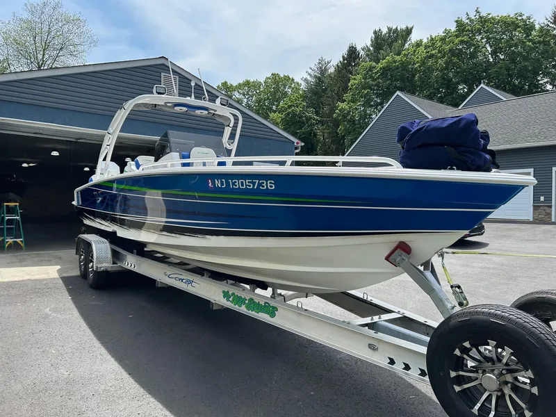 Slide: The Image of 2021 Concept 30 Open boat on trailer, parked outside a garage. - 1