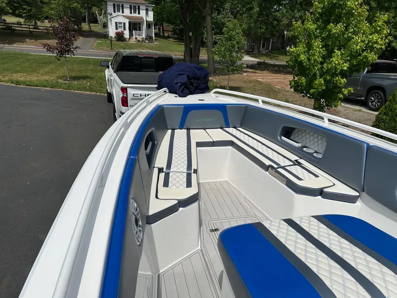 Slide: The Image of 2021 Concept 30 Open boat with blue and white seating, parked near a white truck. - 2
