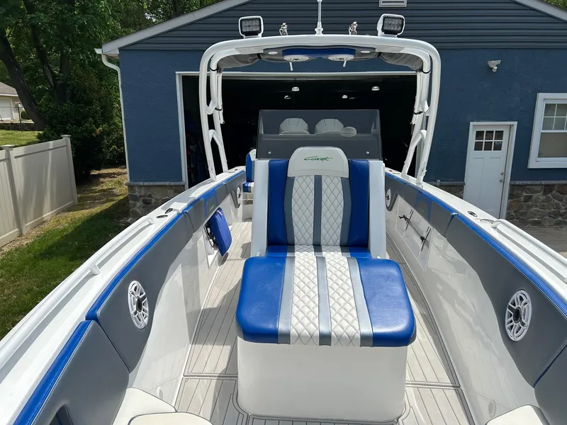 Slide: The Image of 2021 Concept 30 Open boat with blue and white seating, docked near a blue garage. - 3