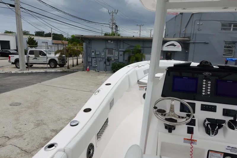 Slide: The Image of 2024 Sea Fox 268 Commander boat with modern dashboard and steering, parked outdoors. - 13