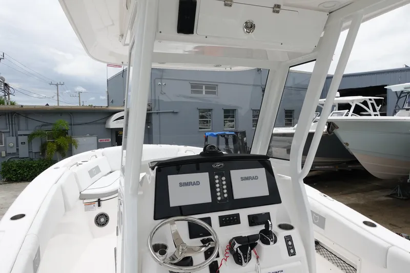 Slide: The Image of 2024 Sea Fox 268 Commander boat dashboard with dual Simrad displays and steering wheel. - 2