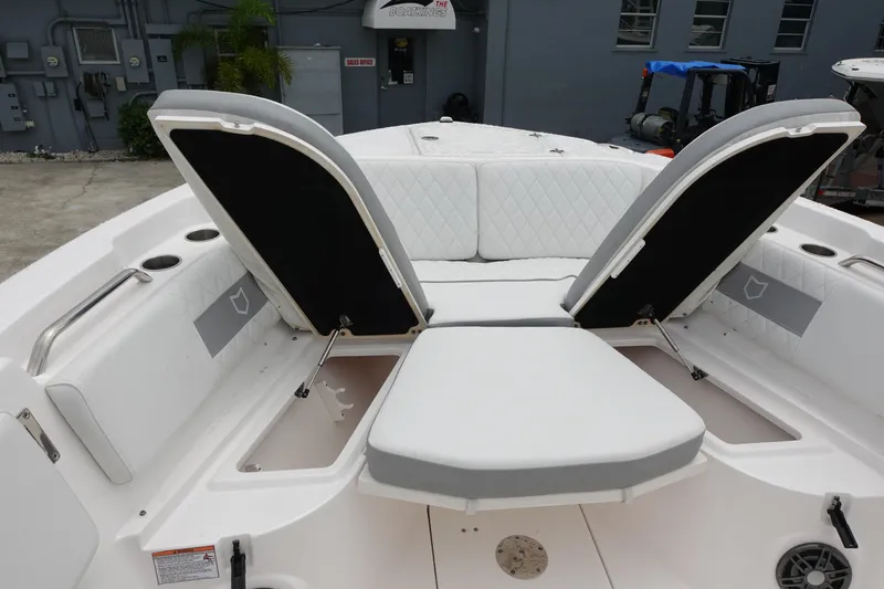 Slide: The Image of 2024 Sea Fox 268 Commander boat with open storage compartments and cushioned seating. - 21