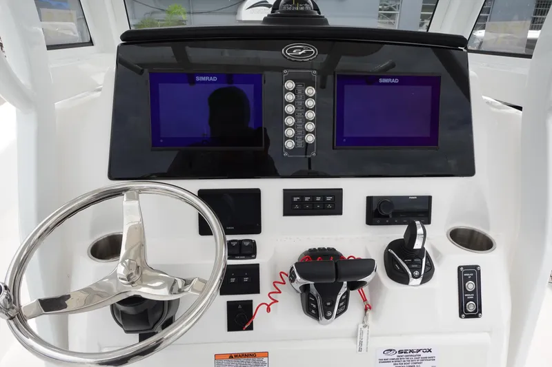Slide: The Image of 2024 Sea Fox 268 Commander dashboard with dual Simrad displays and steering wheel. - 3