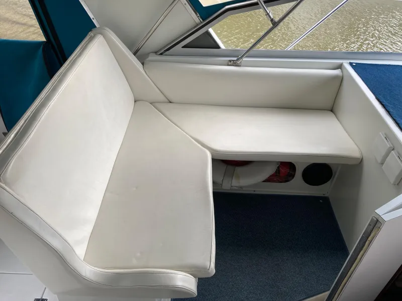 Slide: The Image of 1988 Carver 3257 MONTEGO interior seating with white cushions and blue carpet. - 10