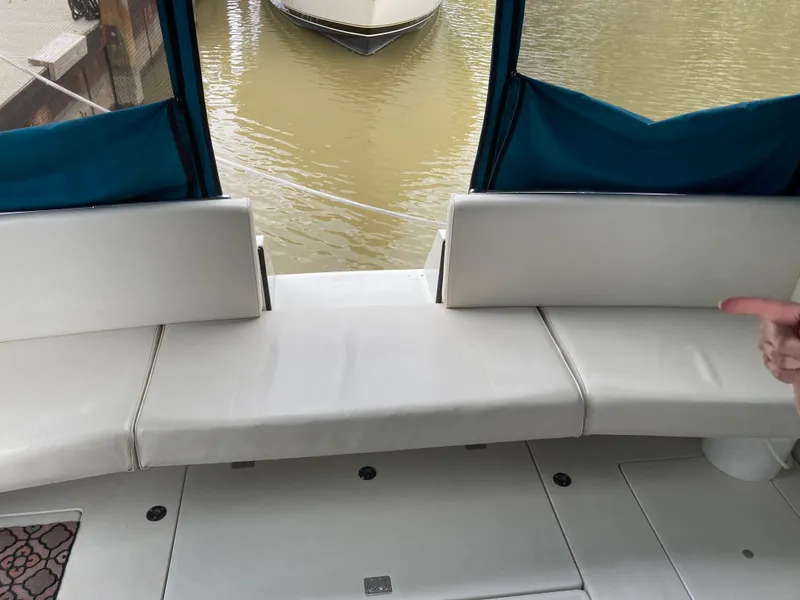 Slide: The Image of 1988 Carver 3257 Montego boat interior with white seating and blue canopy. - 12