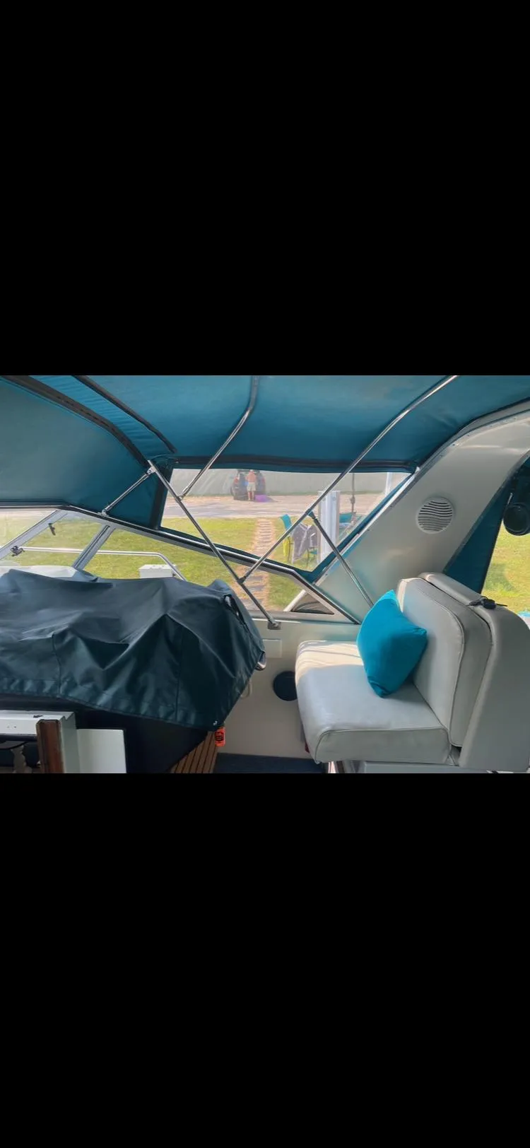 Slide: The Image of 1988 Carver 3257 Montego boat interior with blue canopy and seating. - 2