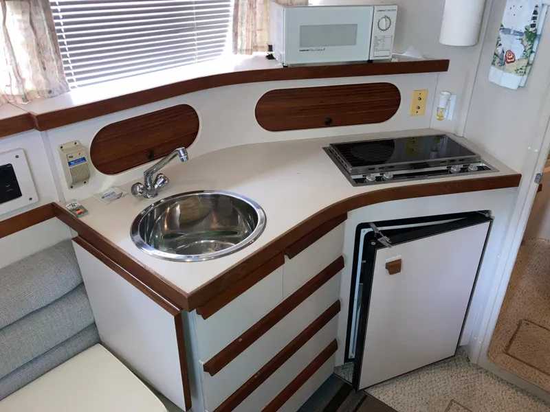 Slide: The Image of 1988 Carver 3257 Montego yacht kitchenette with sink, stove, and microwave. - 21