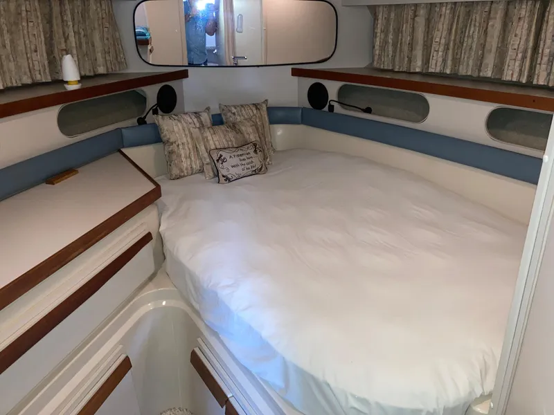 Slide: The Image of 1988 Carver 3257 Montego cabin with cozy bed, pillows, and wooden accents. - 22