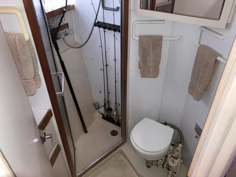 Slide: The Image of 1988 Carver 3257 Montego bathroom with shower, toilet, and fishing rods. - 23