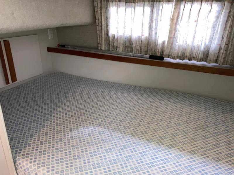 Slide: The Image of Interior cabin of 1988 Carver 3257 MONTEGO with patterned bedding and curtained windows. - 26