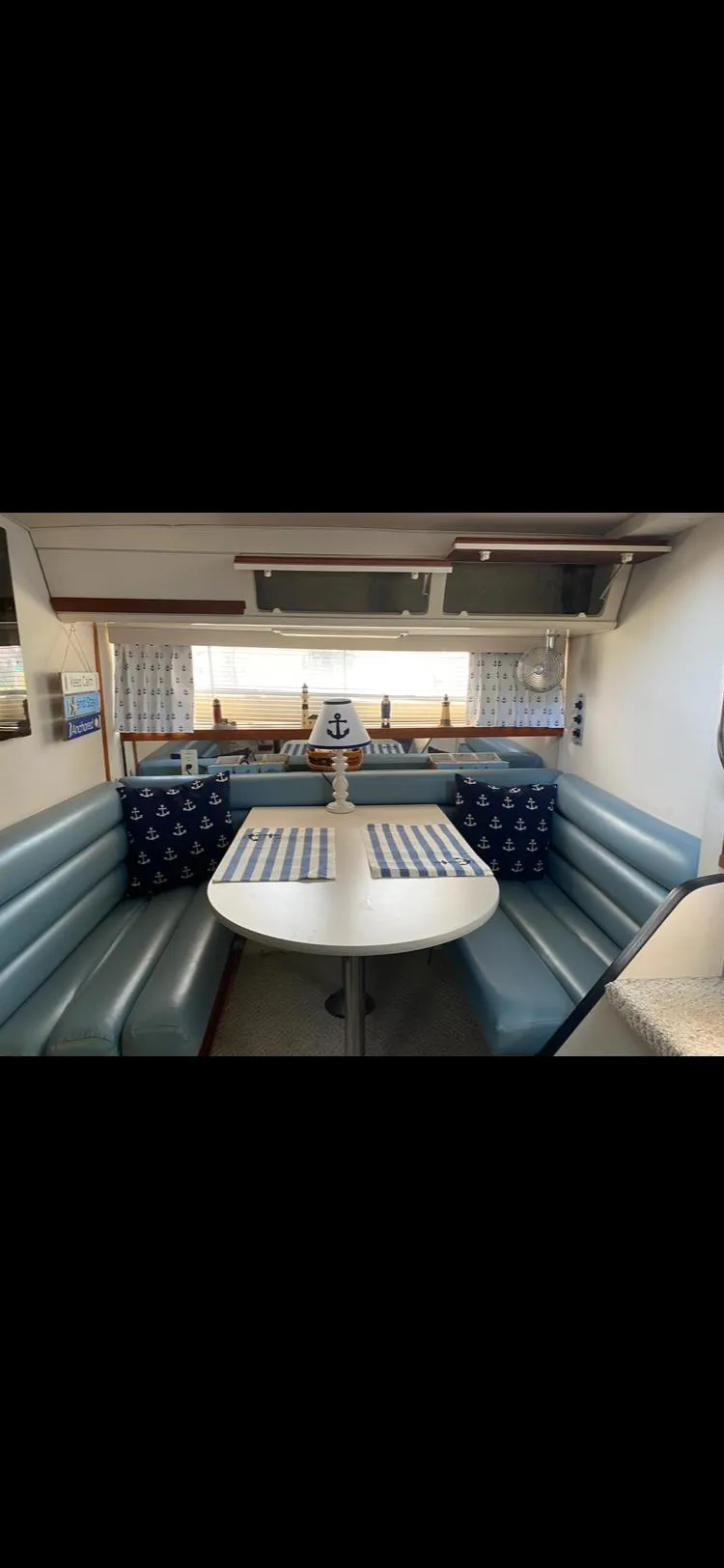 Slide: The Image of 1988 Carver 3257 Montego interior with blue seating and nautical decor. - 6