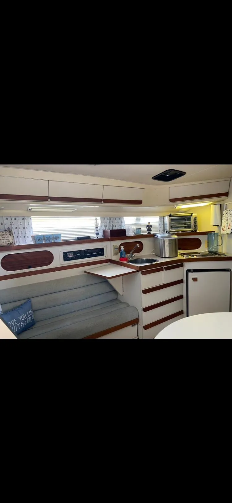 Slide: The Image of 1988 Carver 3257 Montego yacht interior with kitchen and seating area. - 8