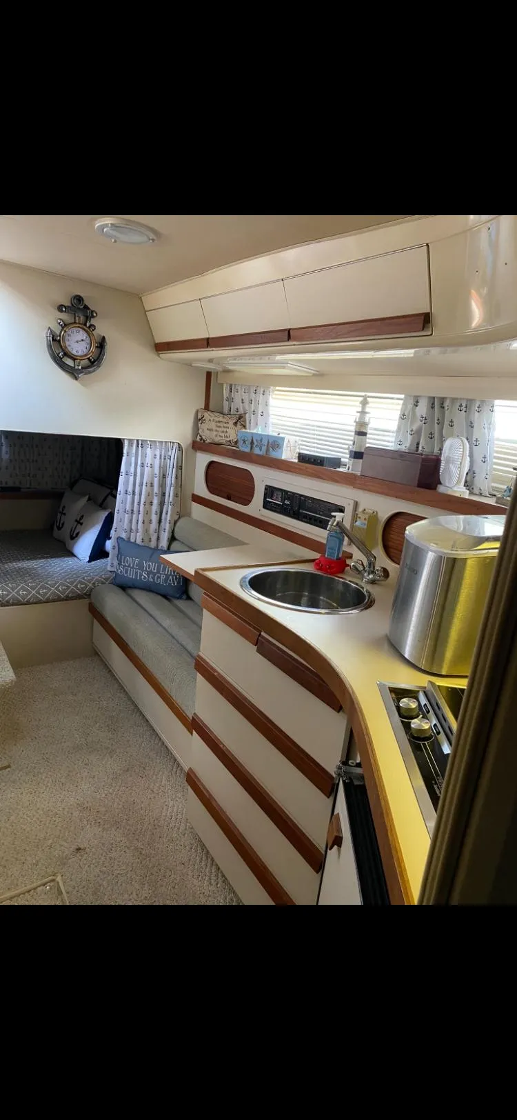 Slide: The Image of 1988 Carver 3257 Montego interior with kitchen, seating area, and nautical decor. - 9